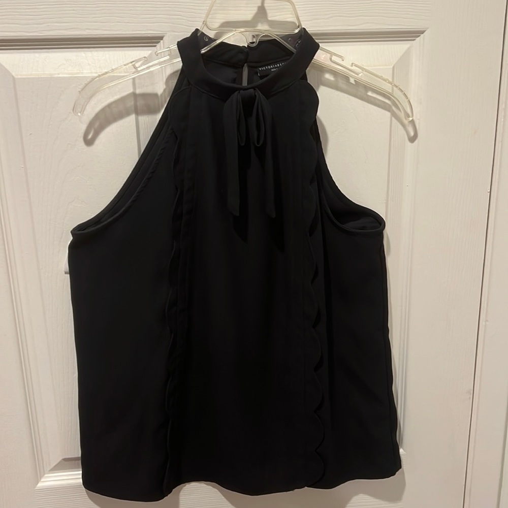 Sleeveless black shirt with scalloped trim and collar tie